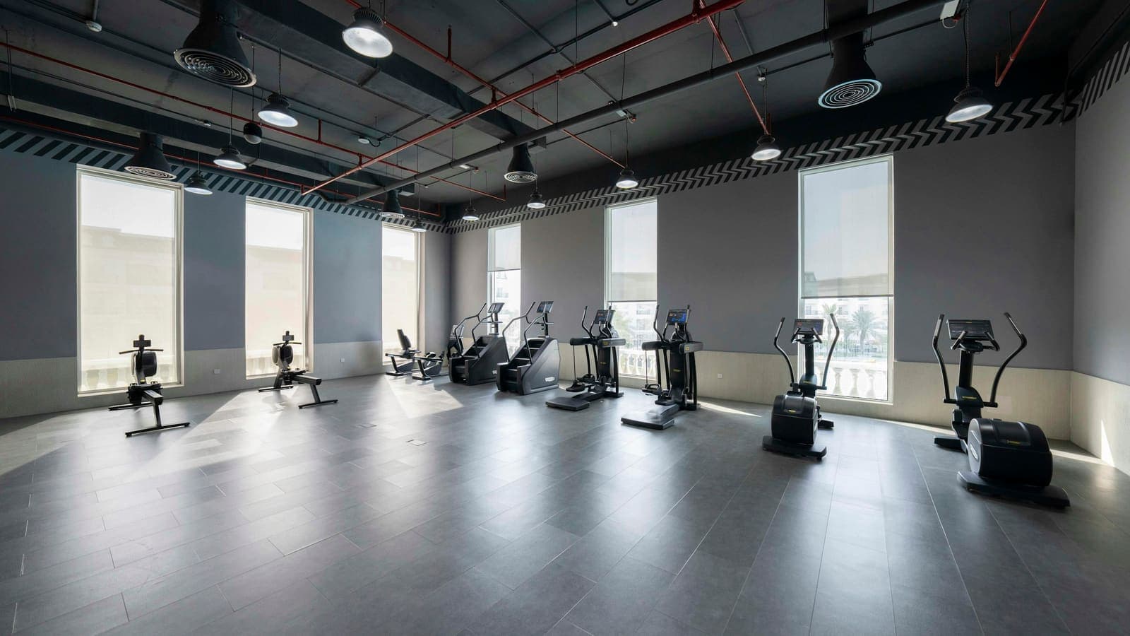 Empty fitness studio with rack of weight plates in low light
